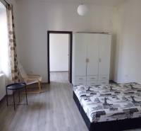 Bedroom in a 3-room apartment with wood-patterned flooring, a wardrobe, and a bed.