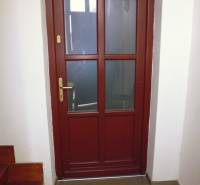 Wooden doors lead from the hallway of a 3-room apartment with a staircase.
