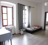 Living room with a table and sofa in a 3-room apartment, floor with wooden decor.