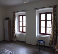 A room with large windows, curtains, and a wooden decor floor in a 3-room apartment.
