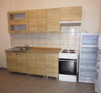 A kitchen unit with a wooden decor and appliances in a 3-room apartment.