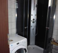 A bathroom in a 3-room apartment with a washing machine and a shower.