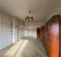 The interior of a family house with retro wallpapers and a wooden living room wall unit.