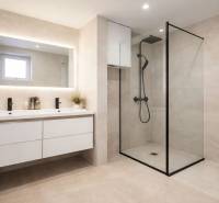 A bathroom with a large mirror and a shower in a family house.