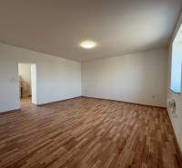 A room in a family house with a wooden decor floor and white walls.