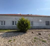 A family house in Zemianska Olča with a gray facade and a tiled roof.