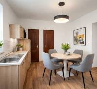 A kitchen in a family house with a wooden decor floor and a round table.