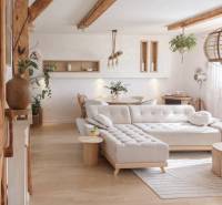 Living room in a family house with a large sofa and wooden decor flooring.