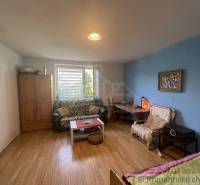 A room in a family house with a wooden decor floor, a couch, and a coffee table.