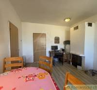 A dining room in a family house with a wooden table and a wooden decor floor.