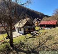 A cottage in Moštenica surrounded by nature and trees on a slope.