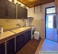A cottage with a rustic kitchen, wooden decor, and stylish cladding.