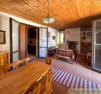 A kitchen in a cabin with a wooden ceiling and rustic furniture.