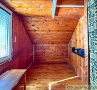 A room in a cabin with a wooden floor decor and a skylight.