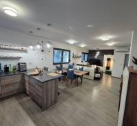 Kitchen and living room with wood-patterned flooring in a family house.