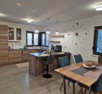 Family house kitchen with wood-patterned flooring, table, and tableware.