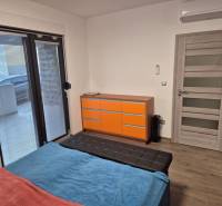 Bedroom in a family house with a bed, wardrobe, and floor with wooden decor.