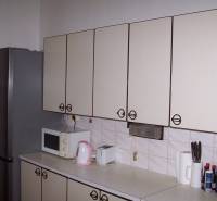 A kitchen unit in a 2-room apartment with a refrigerator, microwave, and kitchen accessories.
