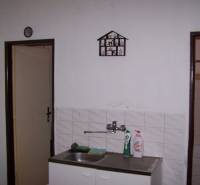 A kitchenette with a hanging dish rack by the sink in a 2-room apartment.