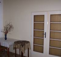 Interior of a 2-room apartment with a dining table and glass doors.