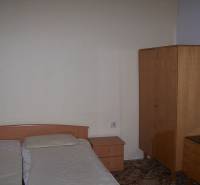 A bedroom in a 2-room apartment with simple furniture and a double bed.