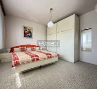 Bedroom in a family house with a large wardrobe, bed, and a picture on the wall.