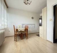 Dining room with wood-patterned flooring, table, and chairs in a family house.