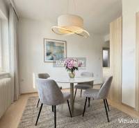 Dining area in a family house with a round table and an elegant light fixture.