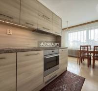 A kitchen in a family house with a wooden decor floor and a dining table.
