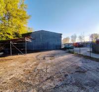 An industrial property with a parking lot surrounded by trees in Nitra, suitable for commercial use.