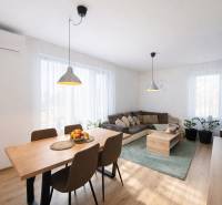 Living room with wood-patterned flooring, a dining table, and a comfortable sofa.
