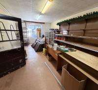Interior of a family house with a storage room, shelves, and wooden door.