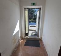 A hallway with older walls and a wooden decor floor in a family house.