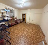 A room in a family house with a floor featuring a wooden decor and simple furniture.
