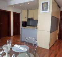 Dining area and kitchen in a 3-room apartment with a wooden decor floor.