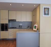 A kitchen in a 3-room apartment with light cabinets and a floor with a wood design.