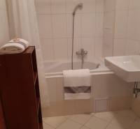 Bathroom in a 3-room apartment with a bathtub and white tiles.