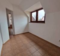 Interior of commercial premises with ceramic flooring and sloped ceiling.
