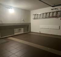 A garage in a family house with ceramic tiles and a ladder on the wall.