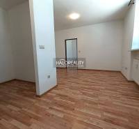 A spacious room in a 2-room apartment with a wooden decor floor and white walls.