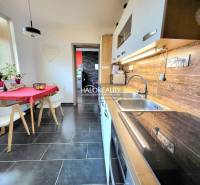 Kitchen in a 3-room apartment with ceramic tiles and a wooden decor floor.