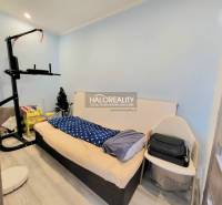 A room in a 3-room apartment with a bed and exercise equipment, wooden decor flooring.