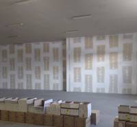 Empty warehouse with concrete floor and scattered cardboard boxes.