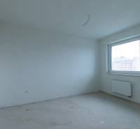 An empty room with white walls in a 2-room apartment, large window, radiator.