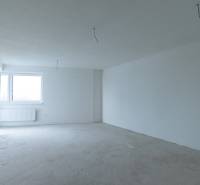 Empty room in a two-room apartment with a window and white walls without furniture.