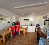 Gastro premises with a wooden decor floor, tables, and refrigerators.