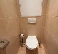 Bathroom with toilet and beige tiles in a 2-room apartment.