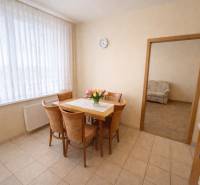 Dining area with a table and chairs, tiles, view into the living room in a 2-room apartment.