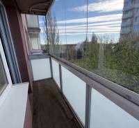 Glazed balcony with a view from a 2-room apartment, floor with wooden decor.