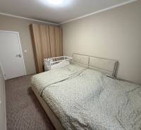 A bedroom with a gray bed, a baby crib, and a wardrobe in a 4-room apartment.